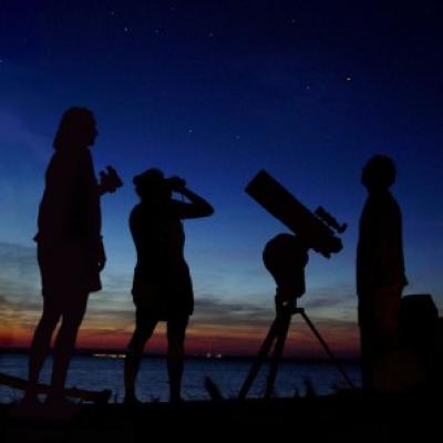 Three people enjoy the summer sky over the Delaware river, NJ, USA during the Perseid meteor shower in August, 2006.