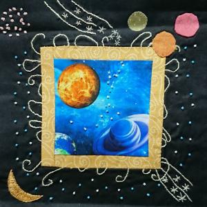 Appliqued planets and embroidered moon and stars stitched onto a black background.