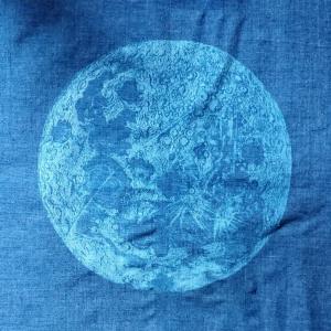 A print of an illustration of the moon on a blue background.