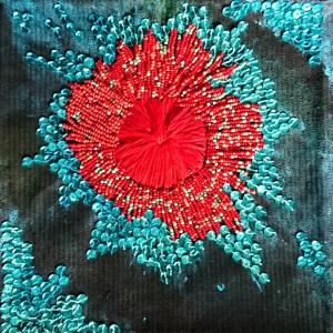 Red and blue beads sewn onto a black background to represent a nebula.