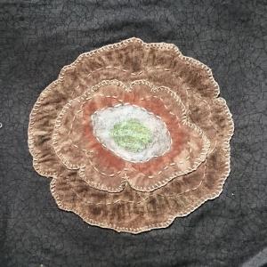 The Ring Nebula created with brown fabric and thread on a black background.