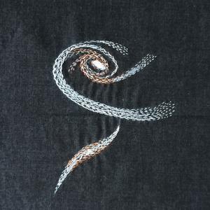 A galaxies embroidered with silvery threads on a black background.