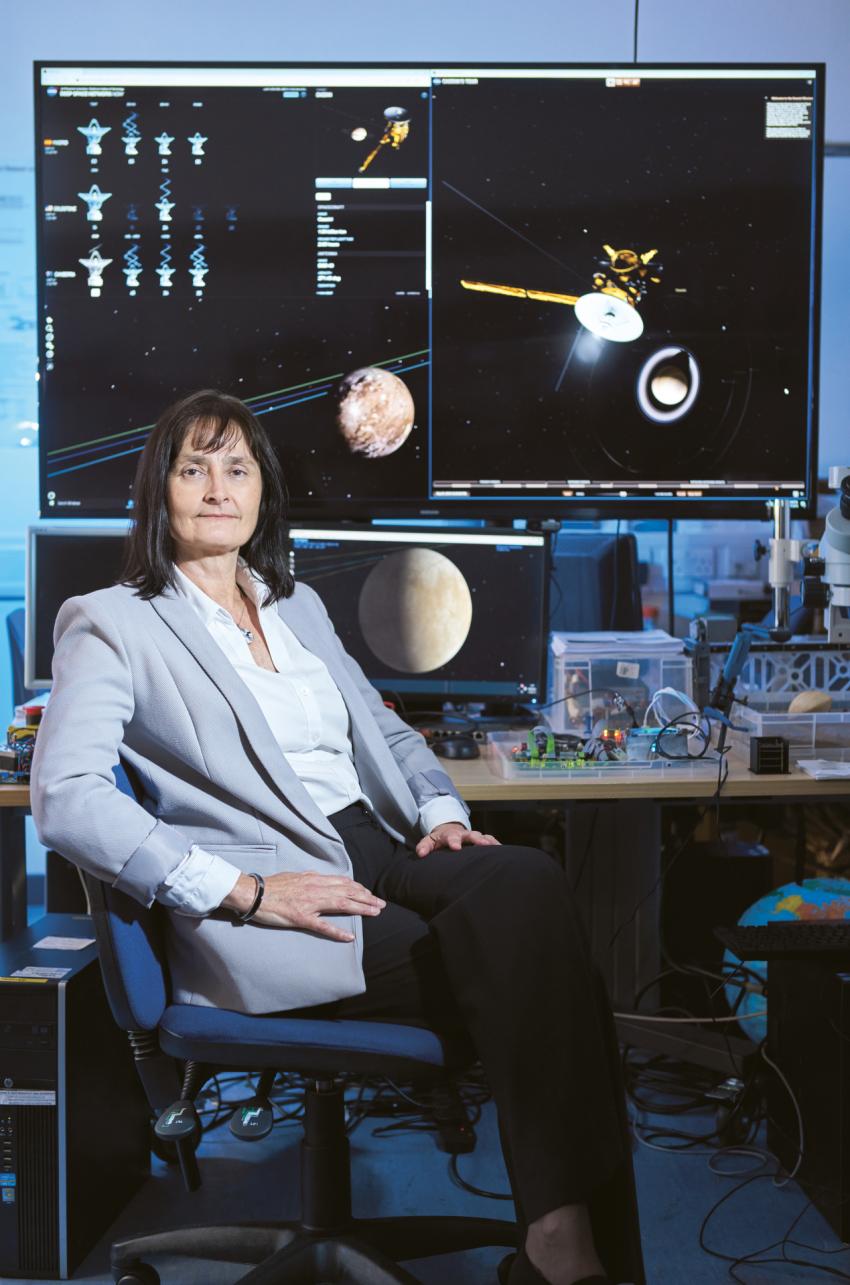 Prof Dougherty sitting in front of monitors showing space objects.