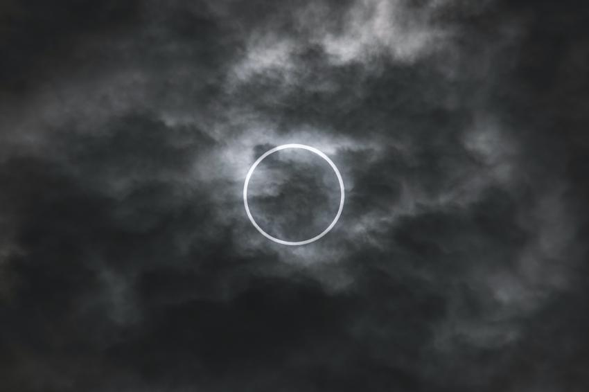 An annular eclipse of the Sun showing a ring of sunlight around the silhouette of the Moon.