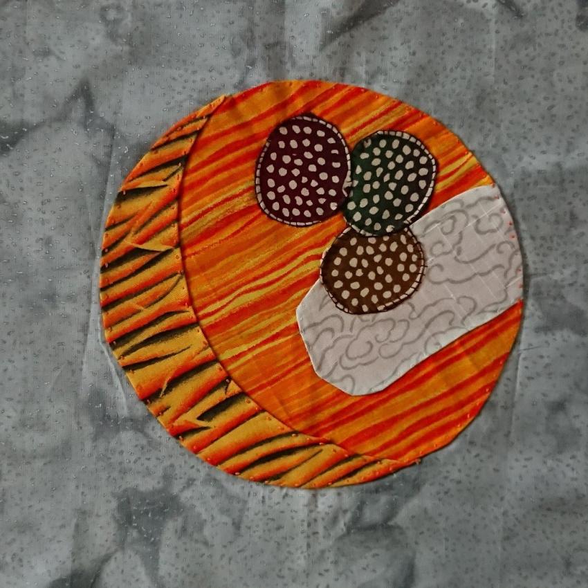 Hand appliqued representation of Venus, clouds and a few microbes.