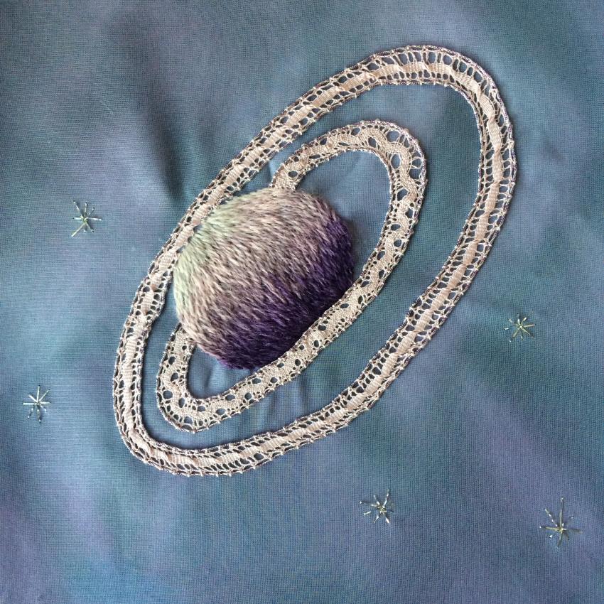 An embroidered planet with rings.