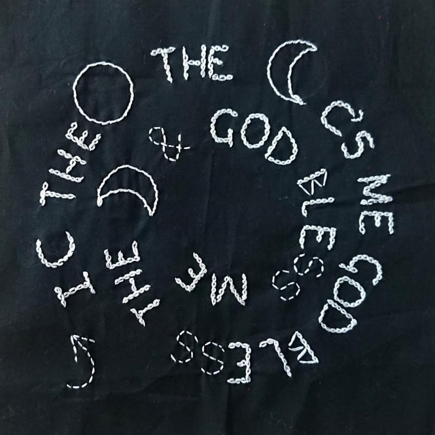 A short poem embroidered in white on a black background, it reads: "I see the moon, the moon sees me, God bless the moon and God bless me."