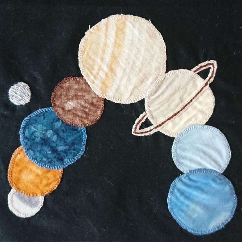 The planets of the solar system appliqued onto a black background.