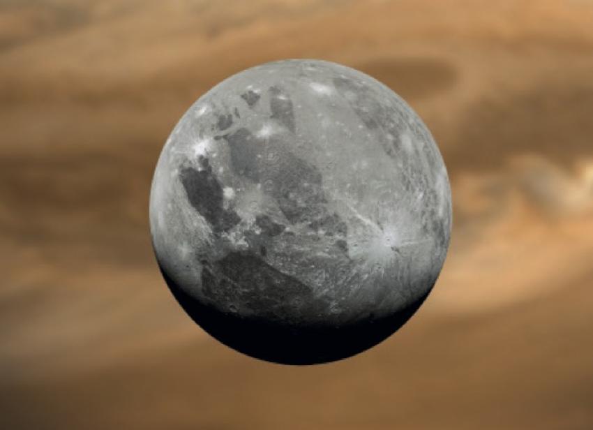 Grey icy moon Ganymede in front of orange Jupiter