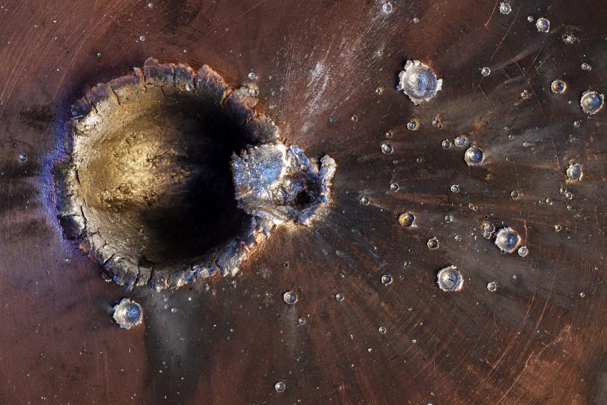 A copper test target from the Hypervelocity Impact Facility at the University of Kent. The laboratory fires projectiles from 3 to 3.5 millimetres across at speeds of 1 to 7.5 kilometres per second. Such hypervelocities are representative of the speeds at which objects hit each other in orbit.