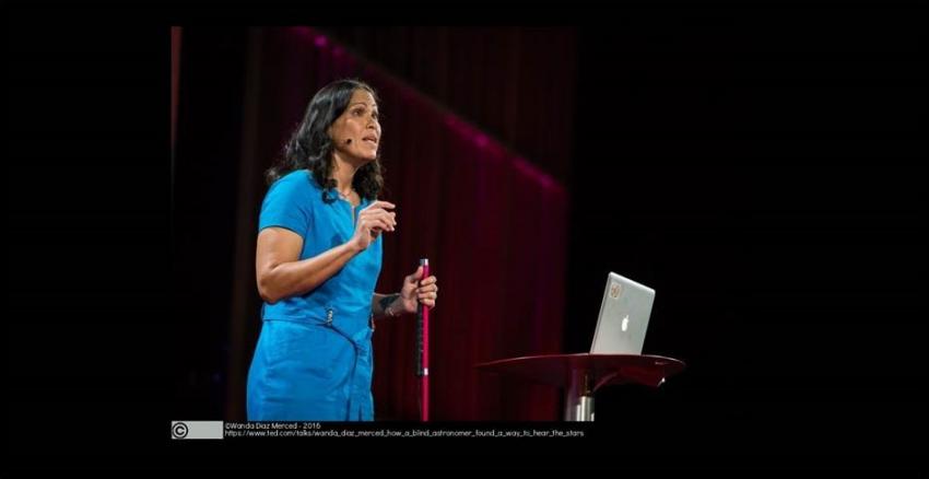 Dr Wanda Diaz-Merced on stage, giving a Ted talk.