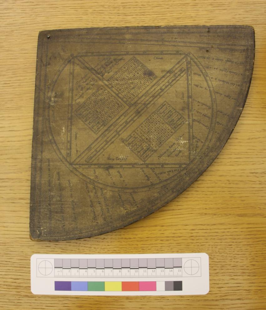 A Sutton-type quadrant, which is an instrument consisting of lines printed on paper which is paper pasted onto wood shaped in a quarter-circle.