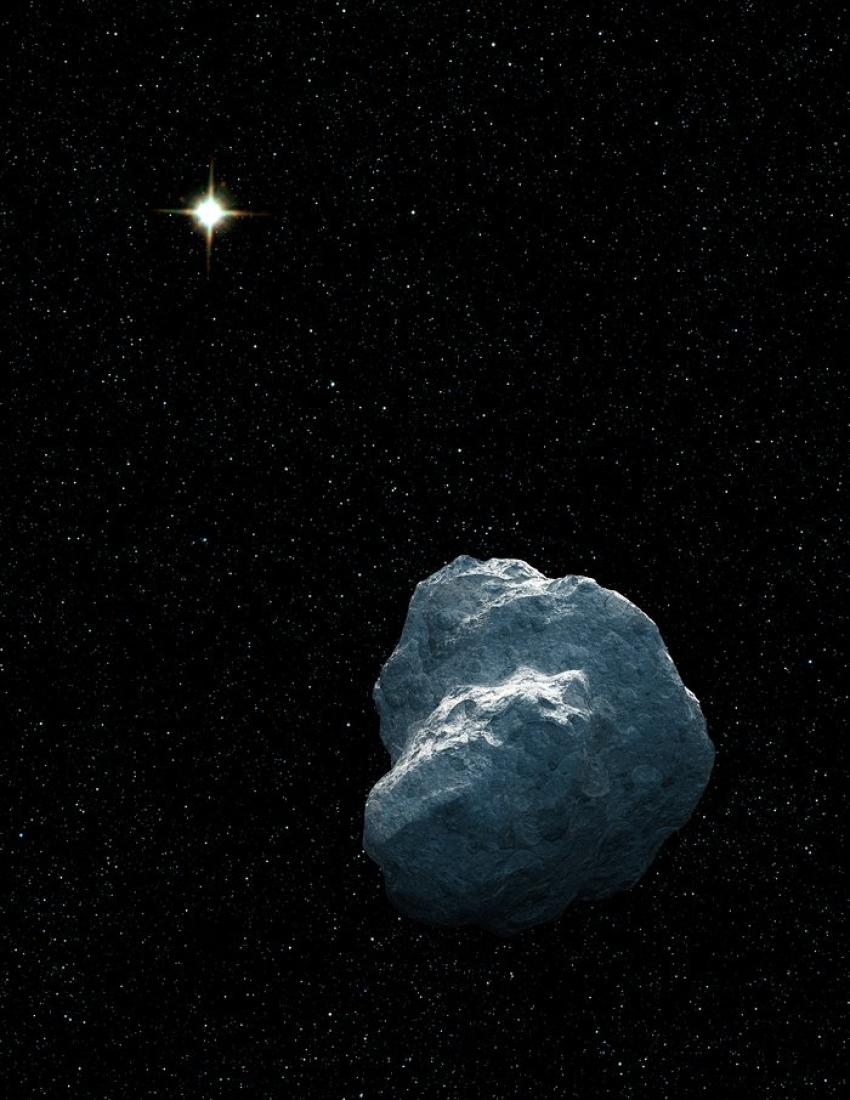 The artist's impression shows a large, grey rocky body in outer space with a bright yellow-white star in the background. Faint stars are also seen in the background.