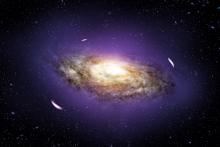 A galaxy surrounded by a coloured haze, with lenses due to gravitational distortion