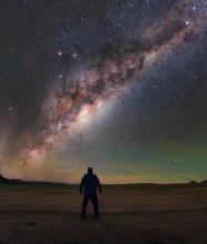 An image of the Milky Way with a person's silhouette in the foreground.